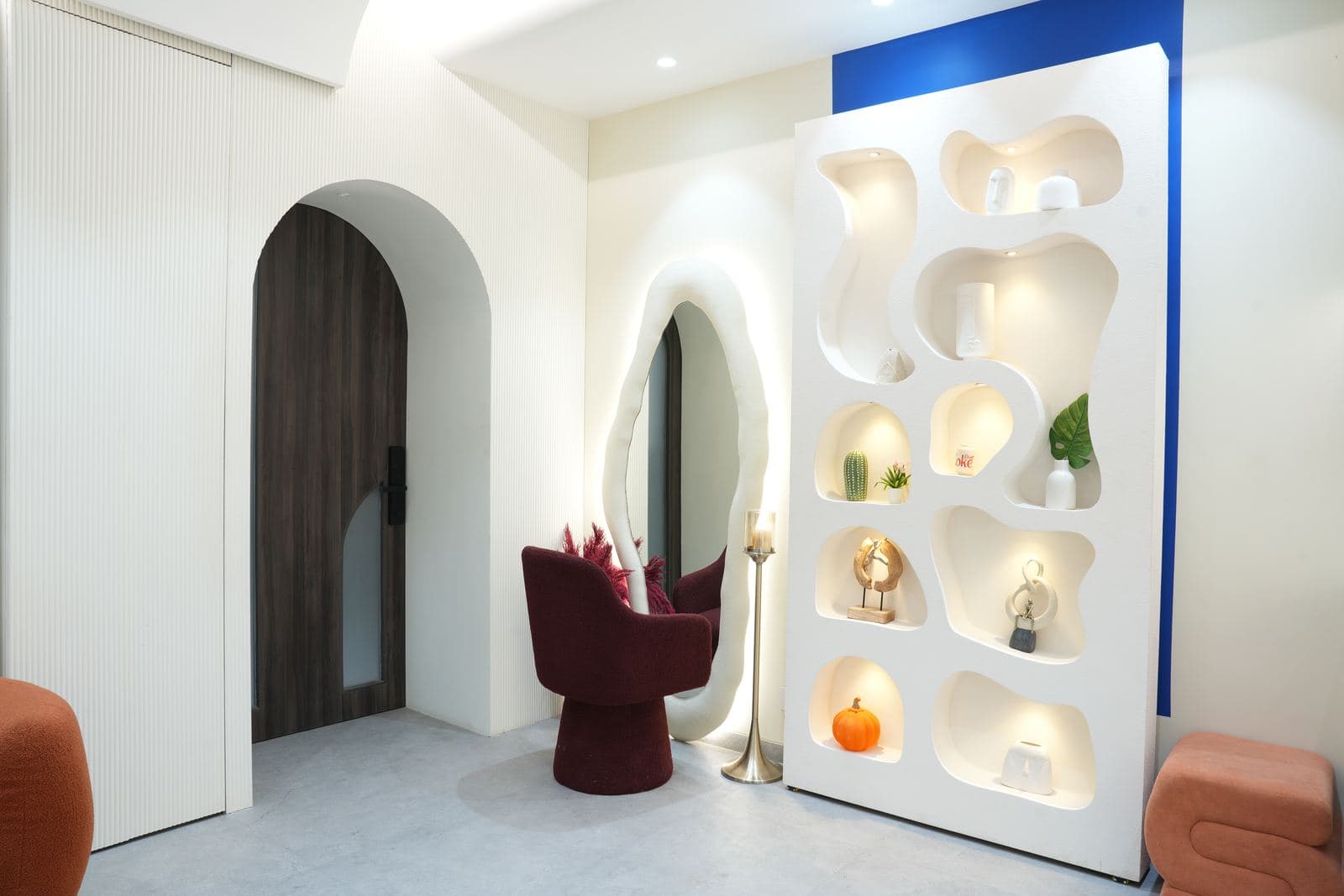 Wider view of the dressing and makeup corner, showing the arched doorway and the aesthetic-wall niche cabinet alongside it.